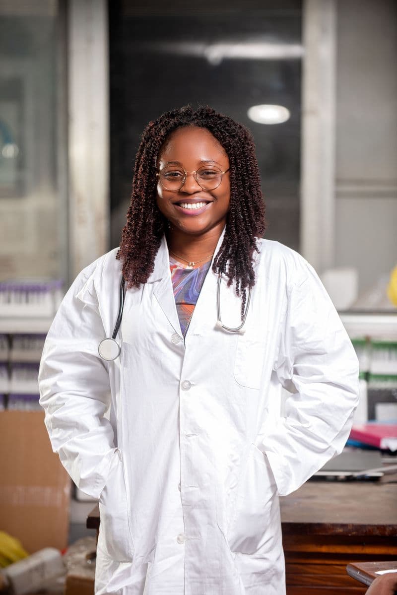 Portrait of Dr. Elise Cardenas, MD, FAAP, smiling in a white coat with a stethoscope and glasses